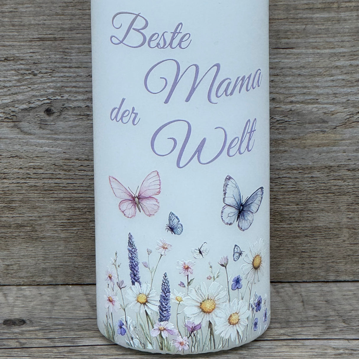 Die Kerze „Beste Mama der Welt“ verbindet romantisches Design mit liebevoller Botschaft. Weiße Kerze, florale Motive und Schmetterlinge, Höhe 150 mm, Durchmesser 60 mm. Ein besonderes Geschenk zum Muttertag, Geburtstag oder als kleine Aufmerksamkeit. Optional auf einem passenden Holz-Kerzenteller arrangierbar. Ein herzerwärmendes Licht für die wichtigste Frau im Leben.