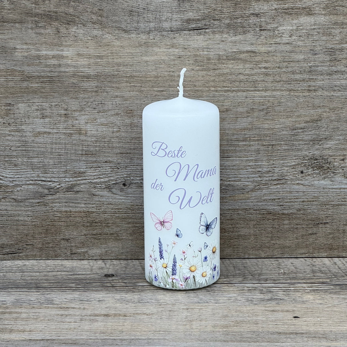 Die Kerze „Beste Mama der Welt“ verbindet romantisches Design mit liebevoller Botschaft. Weiße Kerze, florale Motive und Schmetterlinge, Höhe 150 mm, Durchmesser 60 mm. Ein besonderes Geschenk zum Muttertag, Geburtstag oder als kleine Aufmerksamkeit. Optional auf einem passenden Holz-Kerzenteller arrangierbar. Ein herzerwärmendes Licht für die wichtigste Frau im Leben.