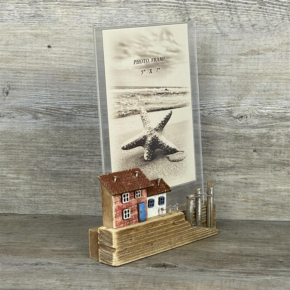 Maritimer Bilderrahmen „Hafenanleger“ – mit bunten Häusern, Bootssteg und Pollern.
Fotofach für 12 x 20 cm, sicher geschützt hinter Acrylglas.
Aufsteller aus Holz, Maße ca. 18 x 10 cm; Gesamtmaß ca. 23 x 18 cm.
Ein dekorativer Blickfang für Wohnräume oder als Küstengeschenk.
Handgefertigt und detailreich – bringt Küstenflair in jedes Zuhause.