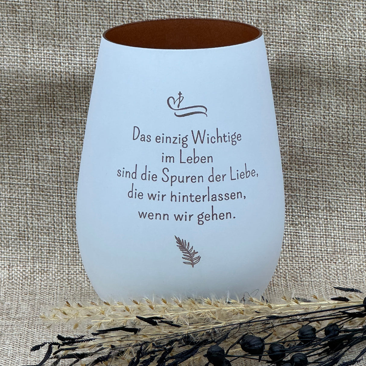 Deko Light – stilvolles Windlicht aus gespritztem Material, spülmaschinenbeständig.
Motiv: „Das einzig wichtige im Leben sind die Spuren der Liebe, die wir hinterlassen, wenn wir gehen“.
Maße: 120 mm hoch, 87 mm Ø, Inhalt 465 ml; Farben: Weiß oder Schwarz mit bronze Innenseite.
Lasergravur verleiht dem Licht eine persönliche und liebevolle Note für Trauernde.
Ein besonderes Geschenk, das Trost spendet und liebevoll an Verstorbene erinnert.
