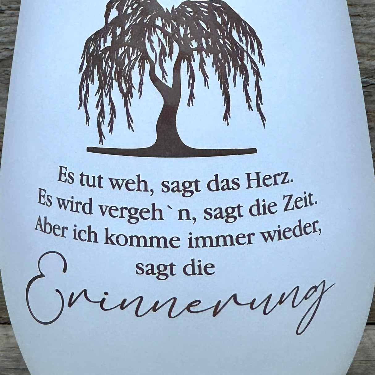Verschenke dieses Deko Light „Erinnerung (Trauerweide)“ als einfühlsames Geschenk für Trauernde. Das Windlicht aus Glas mit Lasergravur und bronzefarbener Innenseite erzeugt stimmungsvolles Licht. Ideal als Geschenk zur Anteilnahme, als Erinnerungsstück oder Trostspender. Perfekt für Familie, Freunde oder Kollegen. Deko Light „Erinnerung (Trauerweide)“ – liebevolles Geschenk für Trauer und Erinnerung.
