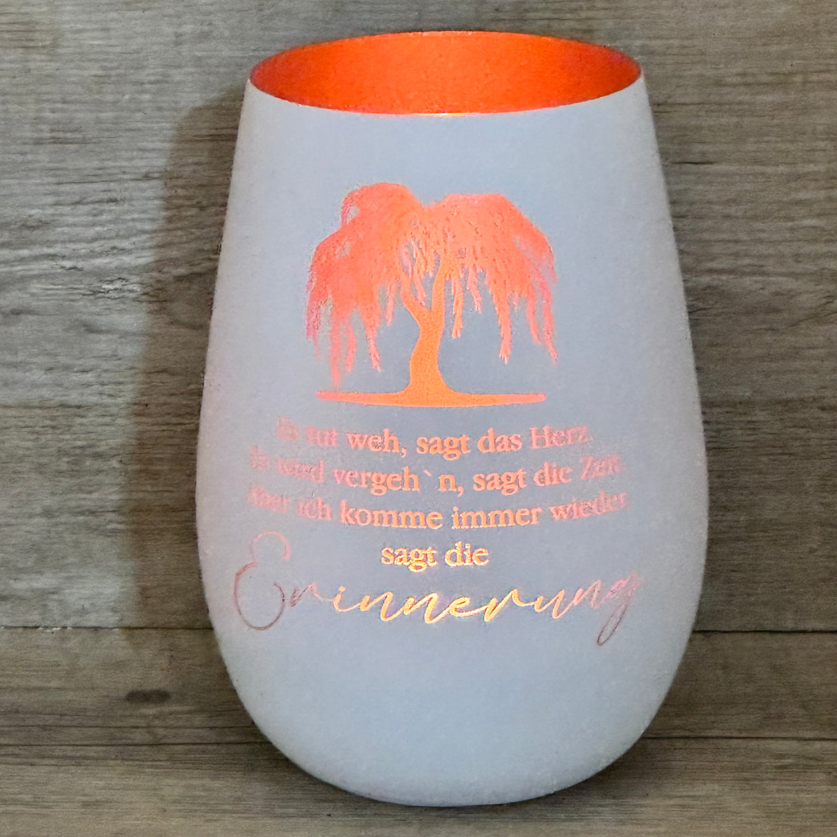 Verschenke dieses Deko Light „Erinnerung (Trauerweide)“ als einfühlsames Geschenk für Trauernde. Das Windlicht aus Glas mit Lasergravur und bronzefarbener Innenseite erzeugt stimmungsvolles Licht. Ideal als Geschenk zur Anteilnahme, als Erinnerungsstück oder Trostspender. Perfekt für Familie, Freunde oder Kollegen. Deko Light „Erinnerung (Trauerweide)“ – liebevolles Geschenk für Trauer und Erinnerung.