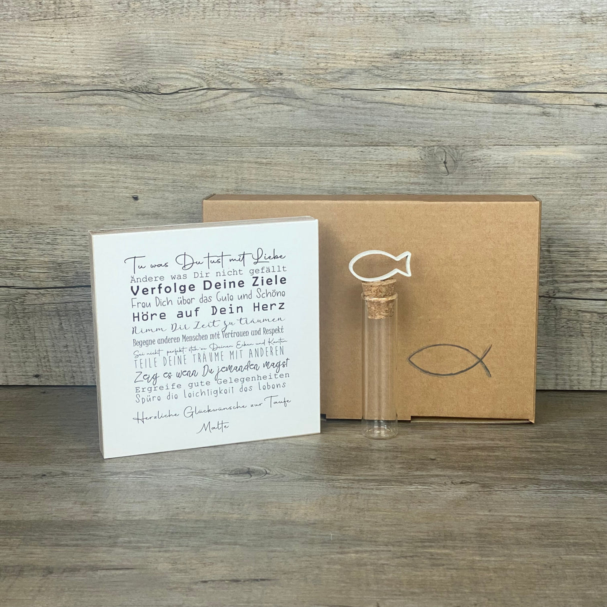 Dieses Taufgeschenk verbindet Persönlichkeit, Symbolkraft und Handwerkskunst. Das Set enthält einen Wooden Block Art „Taufe“ (15 x 15 x 2,2 cm) mit motivierendem Text und Platz für den Wunschnamen. Zusätzlich ein dekoratives Reagenzglas mit Korken & Deko-Fisch (10 x 2,5 cm), perfekt für Geld oder Gutscheine. Die hochwertige Geschenkbox mit christlichen Motiven kann zwischen Fisch oder Kreuz gewählt werden. Ideal für Jungen und Mädchen, nachhaltig und liebevoll gefertigt.