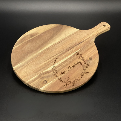 Ein liebevolles Geschenk für Freunde oder Paare: das runde Akazienholz-Pizzabrett mit personalisierter Lasergravur. Mit Namen oder witzigem Spruch wird es zu einem persönlichen Unikat. Optimal für Pizza, Flammkuchen oder Tapas, dekorativ und funktional zugleich. Die natürliche Maserung macht jedes Brett einzigartig. Perfekt für Geburtstage, Einzugspartys, Grillabende oder als originelle Aufmerksamkeit. Ein stilvolles und praktisches Küchenaccessoire.