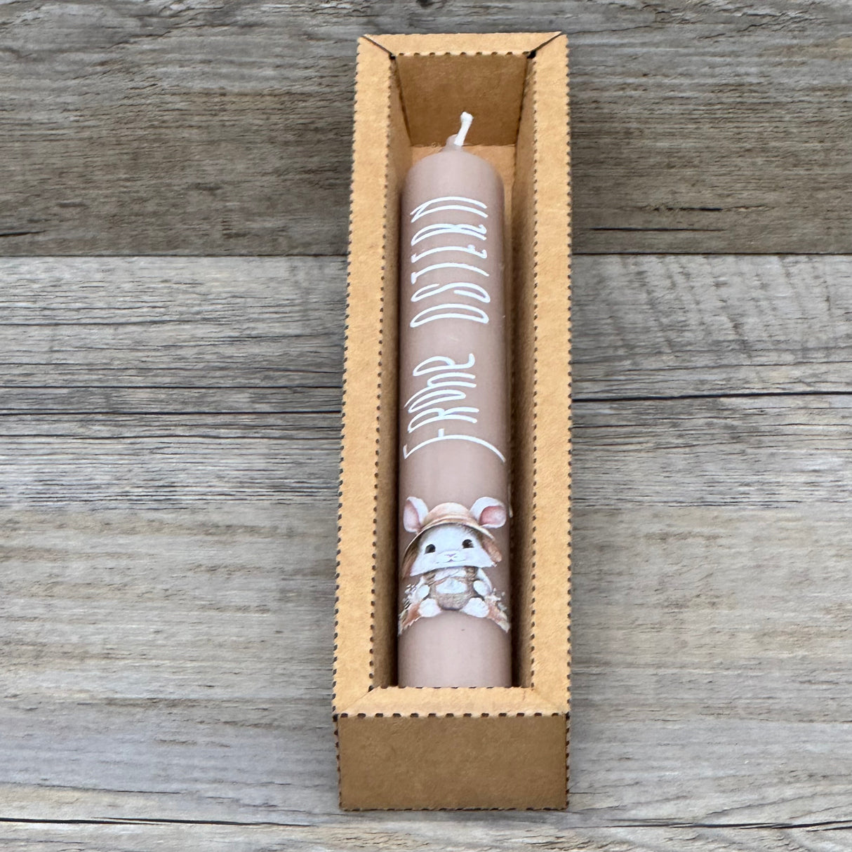 Diese weiße Stabkerze mit fröhlichem Osterhasen und Schriftzug „Frohe Ostern“ ist das perfekte Geschenk für Familie, Freunde oder Kinder – ideal als kleine Aufmerksamkeit zu Ostern. Optional mit Geschenkverpackung und Holzkerzenständer erhältlich. Sie bringt festliche Stimmung in jedes Zuhause und zaubert ein Lächeln auf die Gesichter deiner Liebsten. Dekorativ, hochwertig und liebevoll gestaltet. Ein kleines Geschenk voller Freude und Osterzauber.
