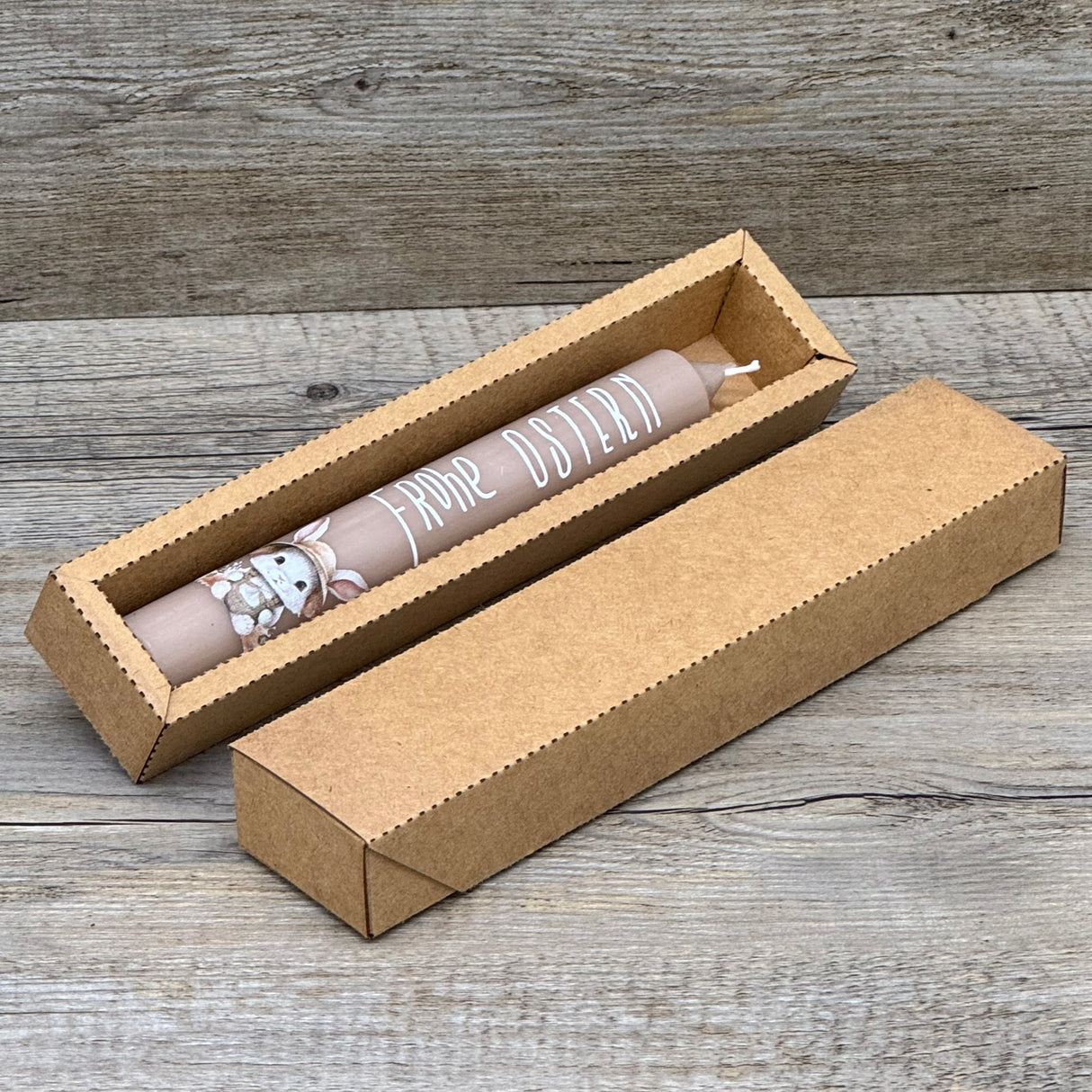 Diese weiße Stabkerze mit fröhlichem Osterhasen und Schriftzug „Frohe Ostern“ ist das perfekte Geschenk für Familie, Freunde oder Kinder – ideal als kleine Aufmerksamkeit zu Ostern. Optional mit Geschenkverpackung und Holzkerzenständer erhältlich. Sie bringt festliche Stimmung in jedes Zuhause und zaubert ein Lächeln auf die Gesichter deiner Liebsten. Dekorativ, hochwertig und liebevoll gestaltet. Ein kleines Geschenk voller Freude und Osterzauber.