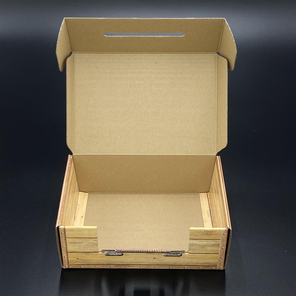 Hochwertiger Koffer aus Karton in edler Holzoptik, bedruckt mit „Auspacken, Anschauen, Ausflippen“. Perfekte Geschenkverpackung für Freunde, Familie oder Kollegen. Maße 23 x 15 x 8 cm, ideal für kleine Präsente und Überraschungen, die elegant und originell verpackt werden sollen.