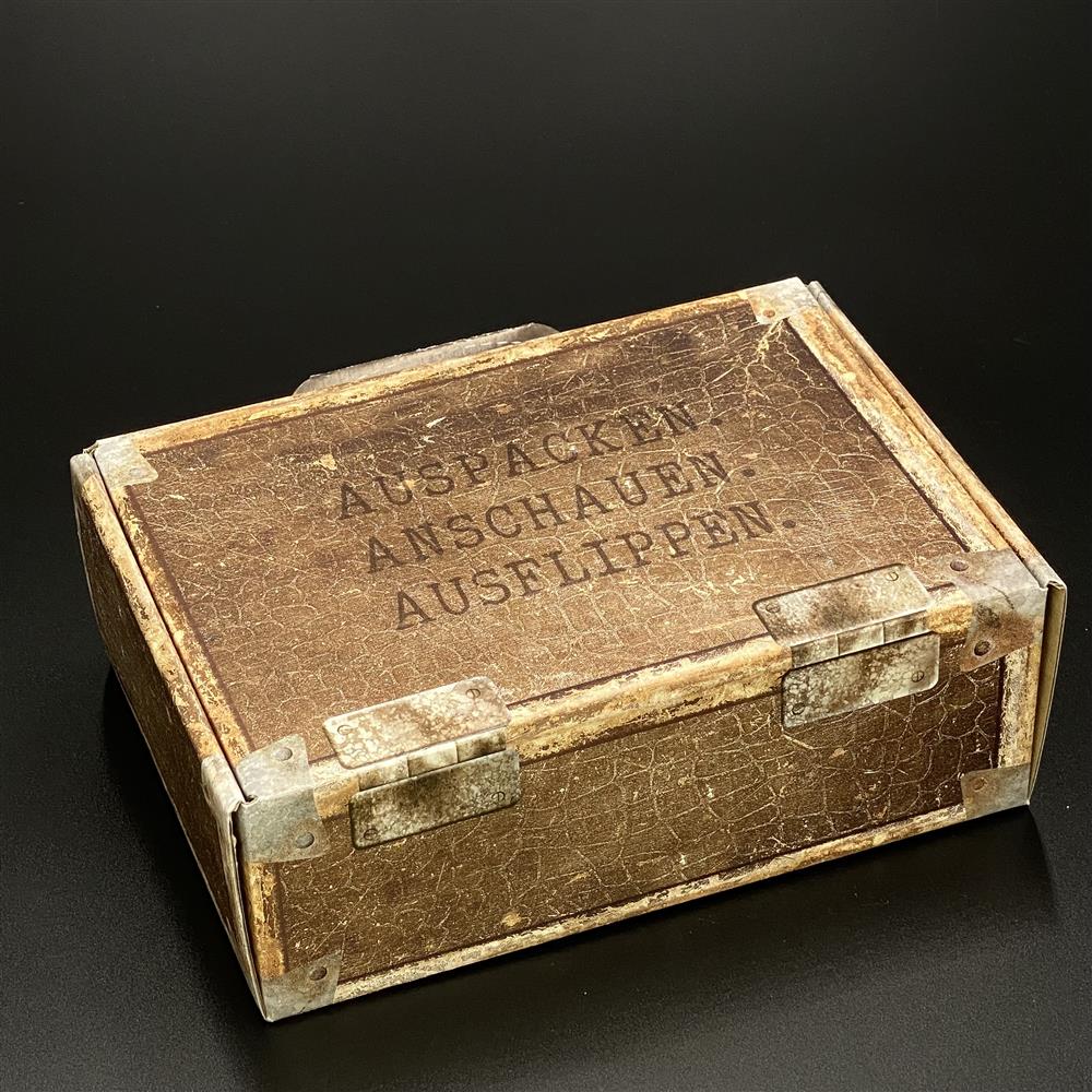 Kleiner Geschenkkoffer aus stabilem Karton in Lederoptik, Maße 23 x 15 x 8 cm, mit fröhlichem Aufdruck „Auspacken, Anschauen, Ausflippen“. Perfekte Geschenkverpackung für Geburtstage, Partys oder besondere Anlässe. Elegantes, hochwertiges Design für stilvolle Präsentationen von Geschenken oder als dekorativer Aufbewahrungsort.