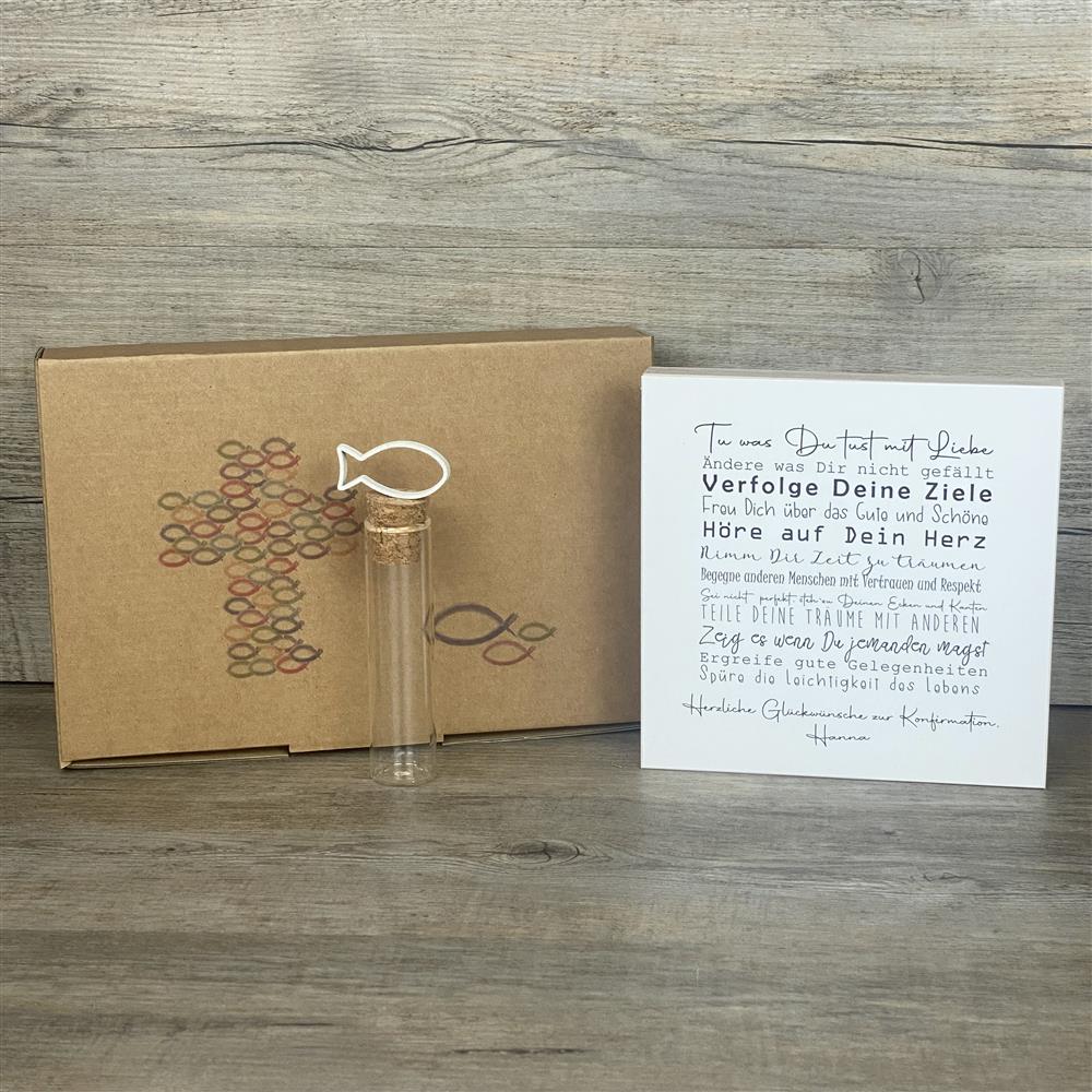 Dieses liebevoll gestaltete Geschenkset zur Konfirmation enthält einen dekorativen Wooden Block Art mit inspirierenden Lebensweisheiten. Auf Wunsch personalisierbar mit Namen, begleitet der Holzblock (15 x 15 x 2,2 cm) den Konfirmanden täglich mit motivierenden Botschaften. Ergänzt wird das Set durch ein Reagenzglas mit Korken und Fisch-Deko, ideal für Geldgeschenke oder Gutscheine. Verpackt in einer hochwertigen Geschenkbox mit christlichen Motiven, entsteht ein individuelles, nachhaltiges und unvergesslic
