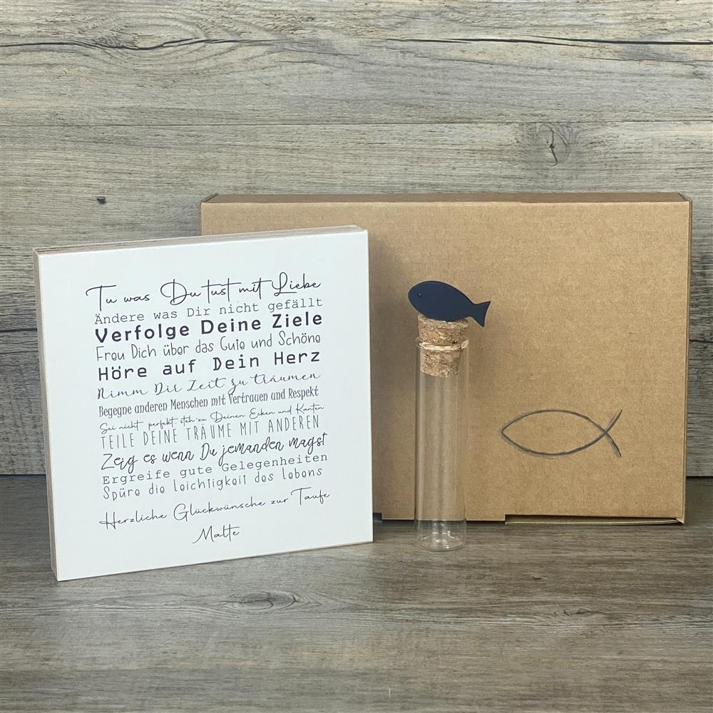 Ein liebevolles Geschenkset zur Taufe – handgefertigt und personalisierbar mit dem Namen des Kindes. Enthalten ist ein Wooden Block Art „Taufe“ (15 x 15 x 2,2 cm) mit inspirierenden Botschaften wie Tue was Du tust mit Liebe, Freu Dich über das Gute und Schöne, Hör auf Dein Herz. Dazu ein Reagenzglas mit Korken und Deko-Fisch (13 x 2,5 cm), ideal für Geldgeschenke oder Gutscheine. Verpackt in einer stilvollen Geschenkbox mit christlichen Motiven, wählbar als Fisch oder Kreuz. Nachhaltig produziert, jedes Stü