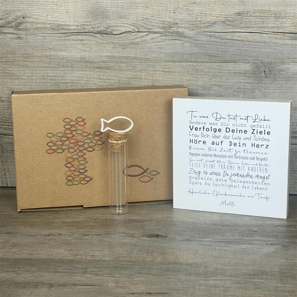 Ein liebevolles Geschenkset zur Taufe – handgefertigt und personalisierbar mit dem Namen des Kindes. Enthalten ist ein Wooden Block Art „Taufe“ (15 x 15 x 2,2 cm) mit inspirierenden Botschaften wie Tue was Du tust mit Liebe, Freu Dich über das Gute und Schöne, Hör auf Dein Herz. Dazu ein Reagenzglas mit Korken und Deko-Fisch (13 x 2,5 cm), ideal für Geldgeschenke oder Gutscheine. Verpackt in einer stilvollen Geschenkbox mit christlichen Motiven, wählbar als Fisch oder Kreuz. Nachhaltig produziert, jedes Stü