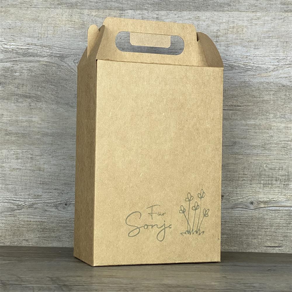 Einzelne Giebelbox aus stabilem Kraftkarton, ca. 22 x 15 x 8 cm, Gesamthöhe inkl. Griff ca. 28 cm. Aufdruck „Für Name“ mit Blumen. Perfekt als Geschenkverpackung für Weihnachten, Geburtstage oder besondere Überraschungen. Wiederverwendbar und nachhaltig, ideal für kleine Präsente, Süßigkeiten oder Mitbringsel für Familie, Freunde und Kollegen.