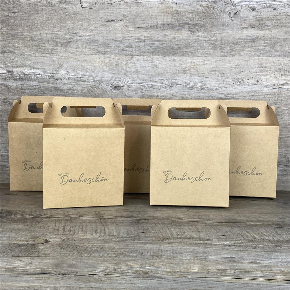 Dieses 5er-Set Giebelverpackungen aus Kraftkarton mit dem Aufdruck „Ein kleines Dankeschön“ ist ideal für liebevolle Geschenke für Kinder, den Sohn, die Tochter oder Enkel. Die Boxen bieten Platz für Süßigkeiten, kleine Spielzeuge oder personalisierte Holzgeschenke. Dank praktischem Griff lassen sie sich leicht transportieren. Perfekt für Geburtstage, Ostern oder andere besondere Anlässe. Ein liebevolles Geschenk mit persönlicher Botschaft.