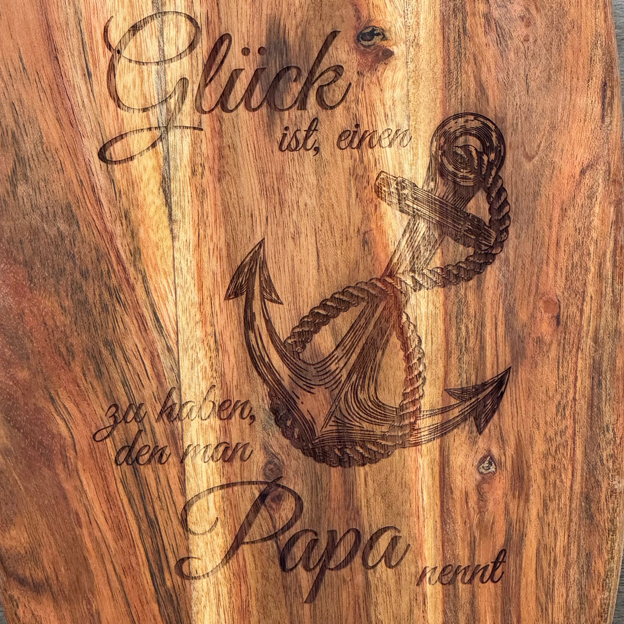 Das Akazienholz-Servierbrett „Glück ist ein Anker“ ist eine besondere Geschenkidee für Väter, Großväter oder Lieblingsmenschen – perfekt zum Geburtstag, Weihnachten oder als Dankeschön. Die hochwertige Gravur mit Spruch und Anker-Motiv macht das Brett einzigartig. Robust, langlebig und stilvoll, ideal für Küche und Servierbereich. Mit Lederband zum Aufhängen ein praktisches Accessoire. Ein liebevolles Präsent, das täglich Freude bereitet.
