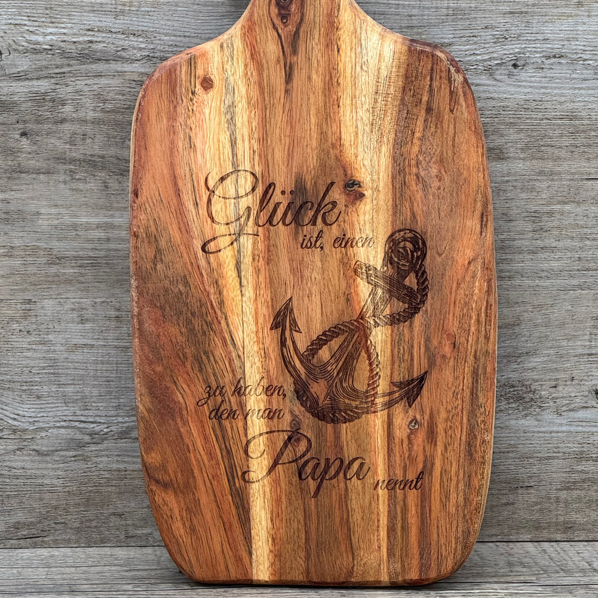 Das Akazienholz-Servierbrett „Glück ist ein Anker“ ist eine besondere Geschenkidee für Väter, Großväter oder Lieblingsmenschen – perfekt zum Geburtstag, Weihnachten oder als Dankeschön. Die hochwertige Gravur mit Spruch und Anker-Motiv macht das Brett einzigartig. Robust, langlebig und stilvoll, ideal für Küche und Servierbereich. Mit Lederband zum Aufhängen ein praktisches Accessoire. Ein liebevolles Präsent, das täglich Freude bereitet.