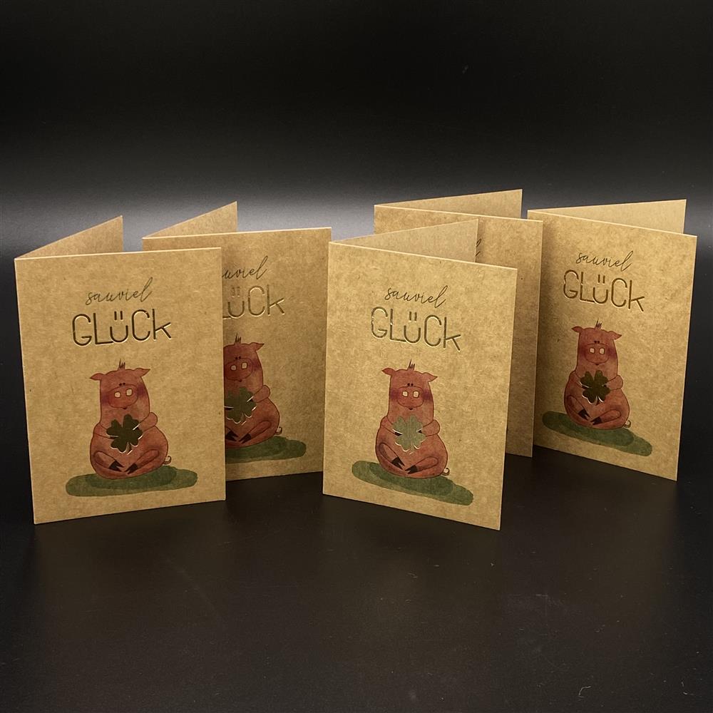 Dieses 5er-Set Grußkarten aus Kraftkarton inklusive farblich abgestimmter Kuverts bringt besondere Freude. Größe je Karte ca. 11 x 15 cm, Motiv: Schwein, Aufdruck „Sauviel Glück“ mit edler Goldprägung auf „Glück“ und Kleeblatt. Hochwertig, liebevoll gestaltet und ideal für Geburtstagsgrüße oder kleine Glücksüberraschungen für Familie und Freunde.