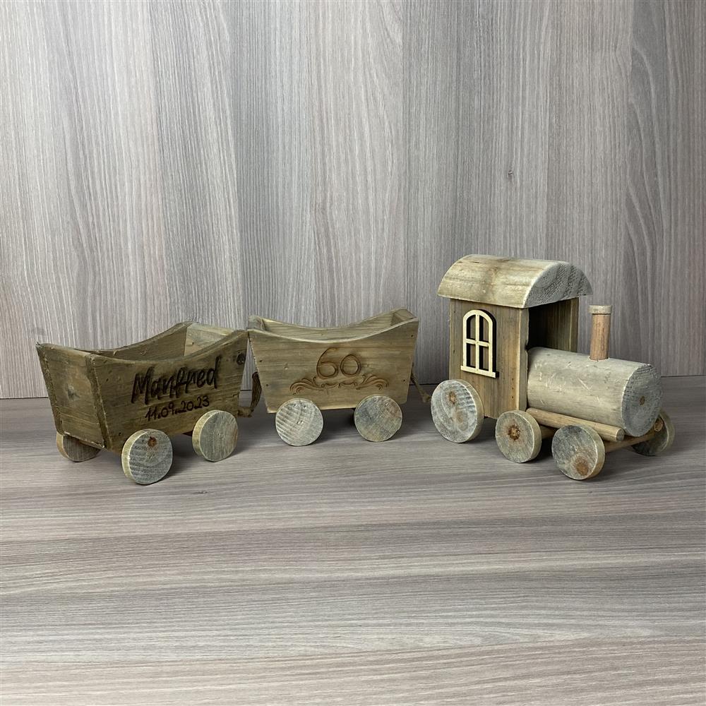 Holzzug aus Treibholz mit zwei Wagen und personalisierbaren Schriftzügen.
Ideal für Namen, Jubiläumsdatum oder besondere Botschaften.
Maße: ca. 57 x 10 x 16 cm – handgefertigt und stabil verarbeitet.
Ein individuelles Geschenk für runde Geburtstage oder Jubiläen.
Perfekt als stilvolle Dekoration und bleibende Erinnerung.