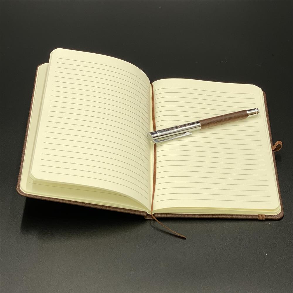 Das Notizbuch „Ideensammler“ mit personalisierbarer Gravur ist ein elegantes Schreibset aus Metall und Nussbaumholz. Liniert, 80 Seiten, inklusive hochwertigem Rollerball. Mit Wunschnamen versehen, eignet es sich perfekt als Geschenk für Studenten, Kreative oder Berufstätige. Ein stilvolles und persönliches Accessoire für Notizen, Gedanken oder Skizzen. Praktisch und edel zugleich.