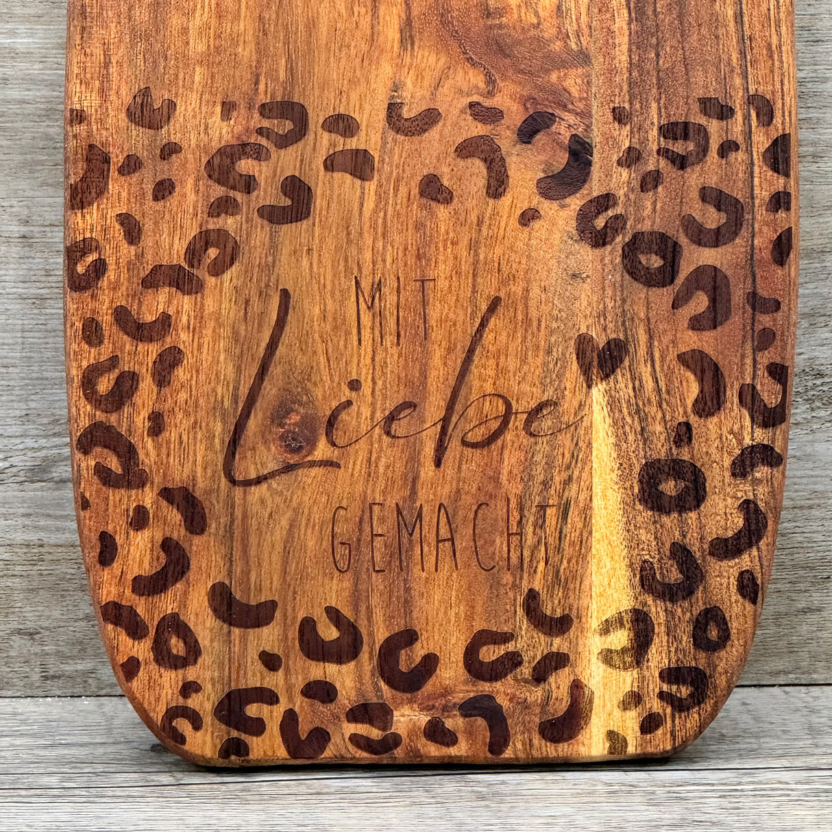 Das Akazienholz-Servierbrett „Mit Liebe gemacht“ ist eine besondere Geschenkidee für Paare, Freunde oder Kollegen – perfekt zur Einweihung, zum Jubiläum oder als persönliche Aufmerksamkeit. Die filigrane Gravur sorgt für eine individuelle, liebevolle Botschaft. Robust, formstabil und vielseitig einsetzbar für Servieren oder Dekoration. Praktisch mit Lederband zum Aufhängen. Ein stilvolles Geschenk für alle, die Genuss und Herzlichkeit schätzen.