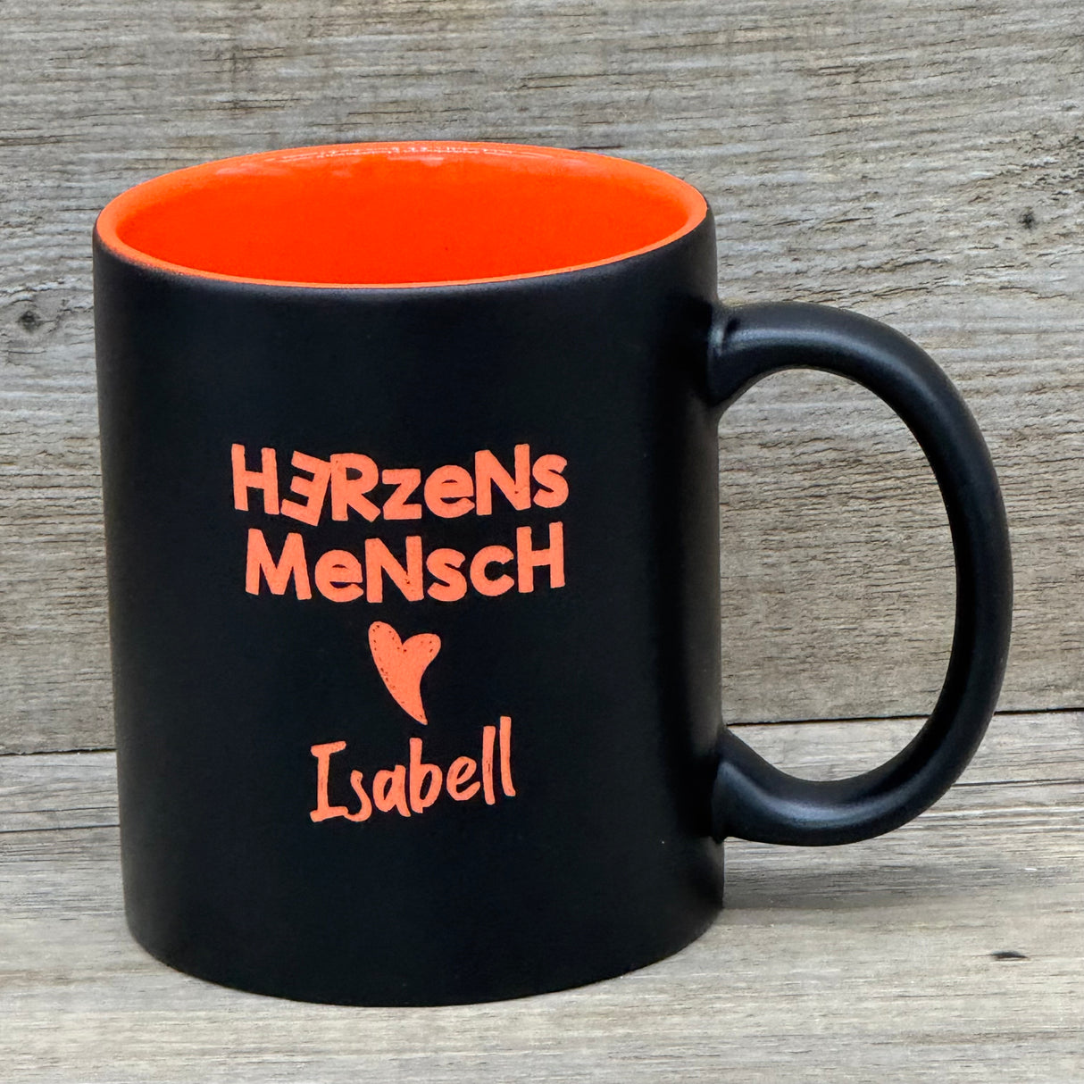 Diese personalisierte Keramik-Tasse „Herzensmensch“ mit schwarzer Außenseite und farbiger Innenseite ist ein liebevolles Geschenk für besondere Menschen. Mit Lasergravur „Herzensmensch“ inklusive Herzmotiv und deinem Wunschnamen wird sie zu einem einzigartigen Unikat. Fassungsvermögen 350 ml, Maße ca. Ø 8,2 × 9,6 cm, ideal für Kaffee, Tee oder Kakao. Perfekt für Zuhause, Büro oder als persönliche Aufmerksamkeit.