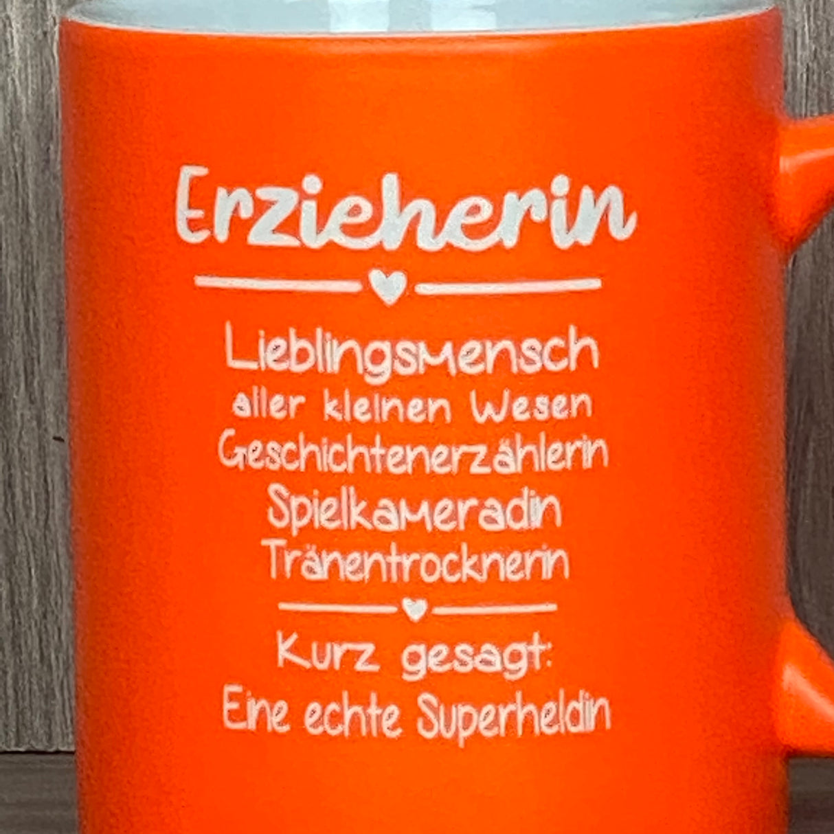 Diese personalisierte Keramik-Tasse „Erzieher/in – Superheld/in des Alltags“ ist das perfekte Dankeschön für besondere Erzieher:innen. Vorderseite mit liebevollem Gravurtext, Rückseite optional mit Wunschnamen personalisierbar. Fassungsvermögen 350 ml, Maße ca. Ø 8,2 × 9,6 cm, farbige Außenseite für fröhlichen Akzent. Ideal zum Abschied, Geburtstag oder als liebevolle Anerkennung für ihre tägliche Arbeit.