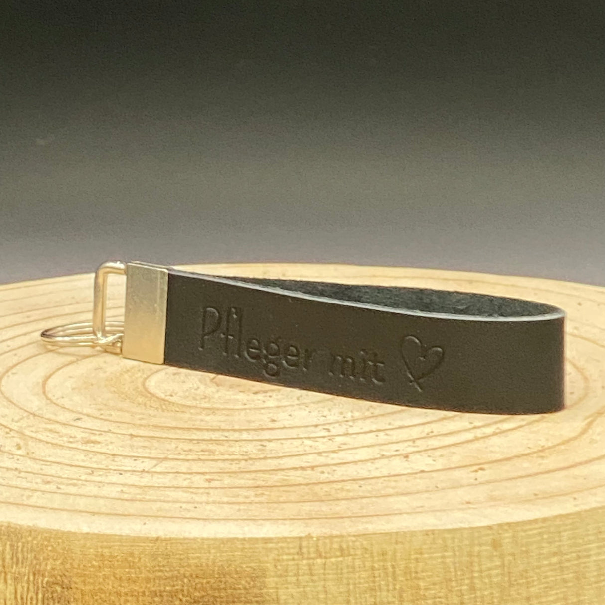 Schlüsselband Pflegekraft aus echtem Leder – schwarz, mit Aufschrift ‚Pfleger mit Herz‘, optional personalisierbar.