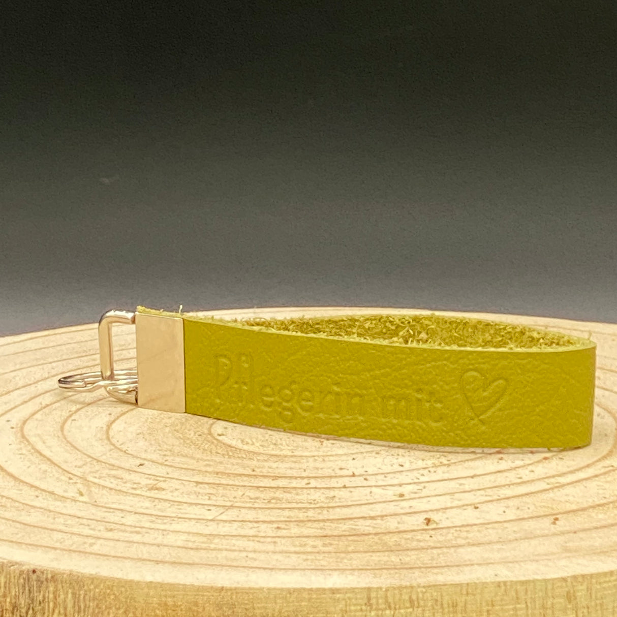 Geschenk für Pflegekräfte: Leder-Schlüsselband in Grün mit Blindprägung ‚Pflegerin mit Herz‘ und stabilem Metallverschluss