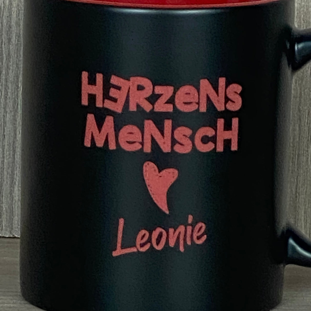 Die Keramik-Tasse „Herzensmensch“ kombiniert elegantes Design mit persönlicher Note. Schwarze Außenseite, farbige Innenseite, 350 ml Volumen, ca. Ø 8,2 × 9,6 cm. Lasergravur mit Herzmotiv und Wunschname macht die Tasse zu einem besonderen Geschenk. Ideal für Geburtstage, Muttertag, Valentinstag oder einfach als kleine Aufmerksamkeit für Freunde, Familie oder Kolleg:innen.