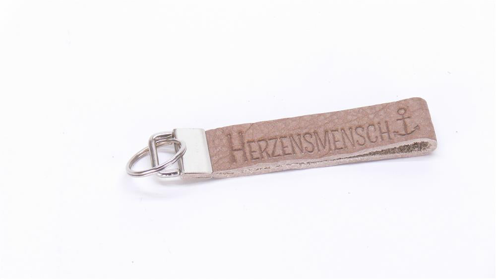 Dieses stilvolle Leder-Schlüsselband eignet sich auch als Geschenk von Teams, Vereinen oder Kollegen für besondere Herzensmenschen. Mit Blindprägung „Herzensmensch“ und personalisierbarem Metallverschluss wird es zu einem exklusiven, persönlichen Präsent. Robust, elegant und voller Symbolkraft – ein Geschenk, das Herz zeigt.