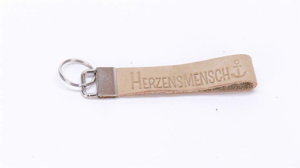 Dieses stilvolle Leder-Schlüsselband eignet sich auch als Geschenk von Teams, Vereinen oder Kollegen für besondere Herzensmenschen. Mit Blindprägung „Herzensmensch“ und personalisierbarem Metallverschluss wird es zu einem exklusiven, persönlichen Präsent. Robust, elegant und voller Symbolkraft – ein Geschenk, das Herz zeigt.