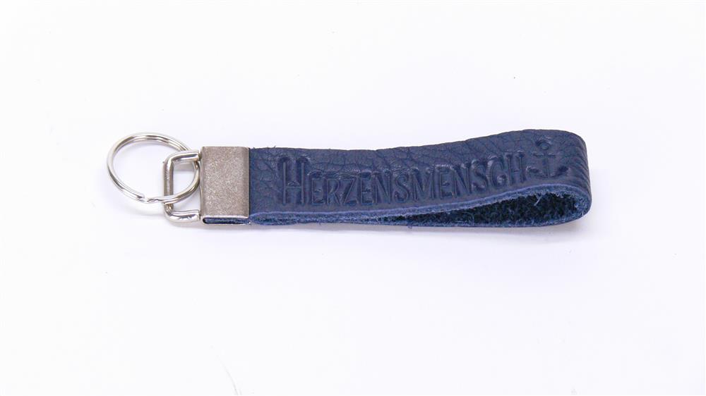 Dieses Echtleder-Schlüsselband „Herzensmensch“ ist ein liebevolles Geschenk für Partner, Freunde oder Familie. Die edle Blindprägung und die Möglichkeit zur Gravur auf dem Metallverschluss machen es zu einem persönlichen, stilvollen Alltagsbegleiter. Robust, handlich und elegant – perfekt als Zeichen von Wertschätzung und Zuneigung zu jedem Anlass.