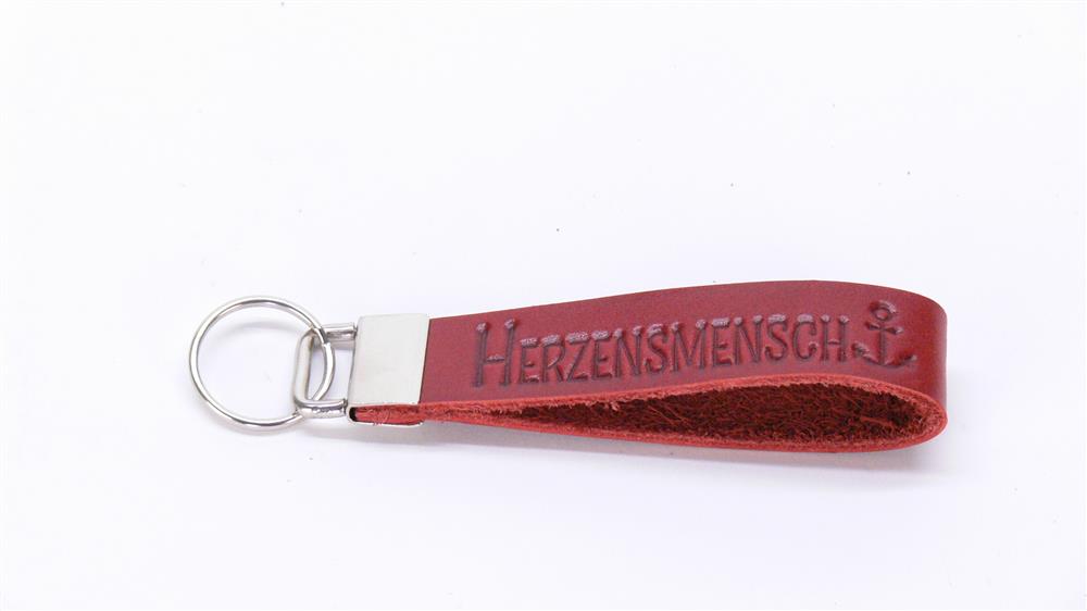 Dieses Echtleder-Schlüsselband „Herzensmensch“ ist ein liebevolles Geschenk für Partner, Freunde oder Familie. Die edle Blindprägung und die Möglichkeit zur Gravur auf dem Metallverschluss machen es zu einem persönlichen, stilvollen Alltagsbegleiter. Robust, handlich und elegant – perfekt als Zeichen von Wertschätzung und Zuneigung zu jedem Anlass.