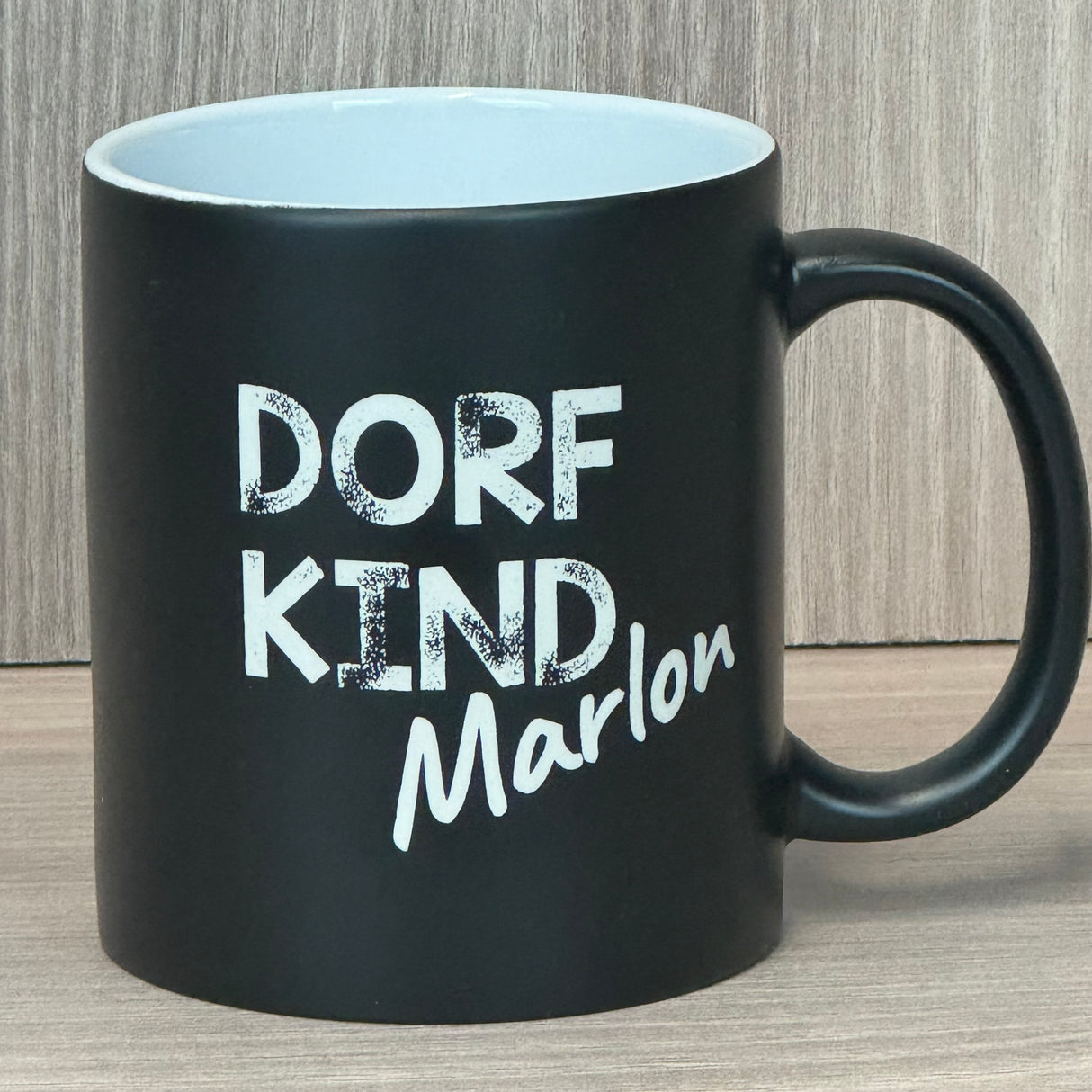 Diese personalisierte Keramik-Tasse mit schwarzer Außenseite und farbiger Innenseite ist ein stilvolles Geschenk für Freunde, Familie oder Kollegen. Lasergravur „Dorfkind“ mit deinem Wunschnamen macht sie zu einem einzigartigen Unikat. Fassungsvermögen 350 ml, Maße ca. Ø 8,2 × 9,6 cm, ideal für Kaffee, Tee oder heiße Schokolade. Praktisch, persönlich und modern – perfekt für den Alltag.