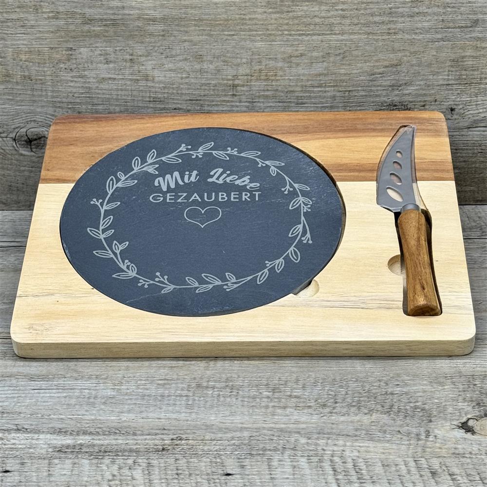 Ein liebevolles Geschenk für Freunde, Paare oder Familie: die Schiefer-Servierplatte „Mit Liebe gezaubert“ mit personalisierbarem Namen. Perfekt für Geburtstage, Einweihungen oder Weihnachten, zum stilvollen Servieren von Käse, Tapas oder kleinen Snacks. Naturschiefer, Akazienholzbrett und Edelstahlmesser sorgen für Qualität und Eleganz. Ein dekoratives, praktisches und individuelles Küchenaccessoire voller Charme.