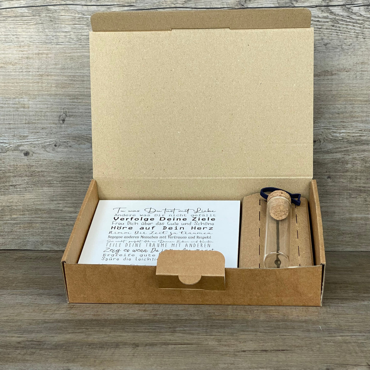 Feiere die Konfirmation mit einem besonderen Geschenkset: Ein personalisierbarer Wooden Block Art mit ermutigenden Sprüchen und ein Reagenzglas mit Fisch-Deko für Geldgeschenke oder Gutscheine. Der Block ist handgefertigt aus Naturmaterialien (15 x 15 x 2,2 cm) und wird zusammen mit der stilvollen Geschenkbox geliefert. Wähle zwischen Fisch- oder Kreuz-Motiv – ein persönliches, liebevoll hergestelltes Geschenk für Jungen und Mädchen.