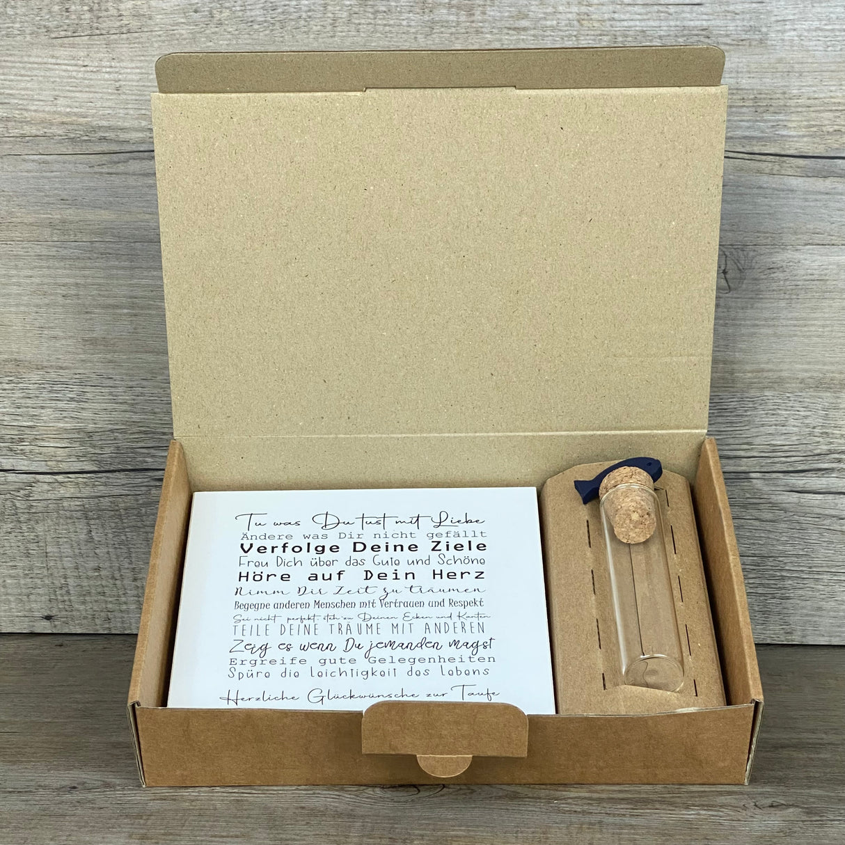 Dieses Taufgeschenk verbindet Persönlichkeit, Symbolkraft und Handwerkskunst. Das Set enthält einen Wooden Block Art „Taufe“ (15 x 15 x 2,2 cm) mit motivierendem Text und Platz für den Wunschnamen. Zusätzlich ein dekoratives Reagenzglas mit Korken & Deko-Fisch (10 x 2,5 cm), perfekt für Geld oder Gutscheine. Die hochwertige Geschenkbox mit christlichen Motiven kann zwischen Fisch oder Kreuz gewählt werden. Ideal für Jungen und Mädchen, nachhaltig und liebevoll gefertigt.