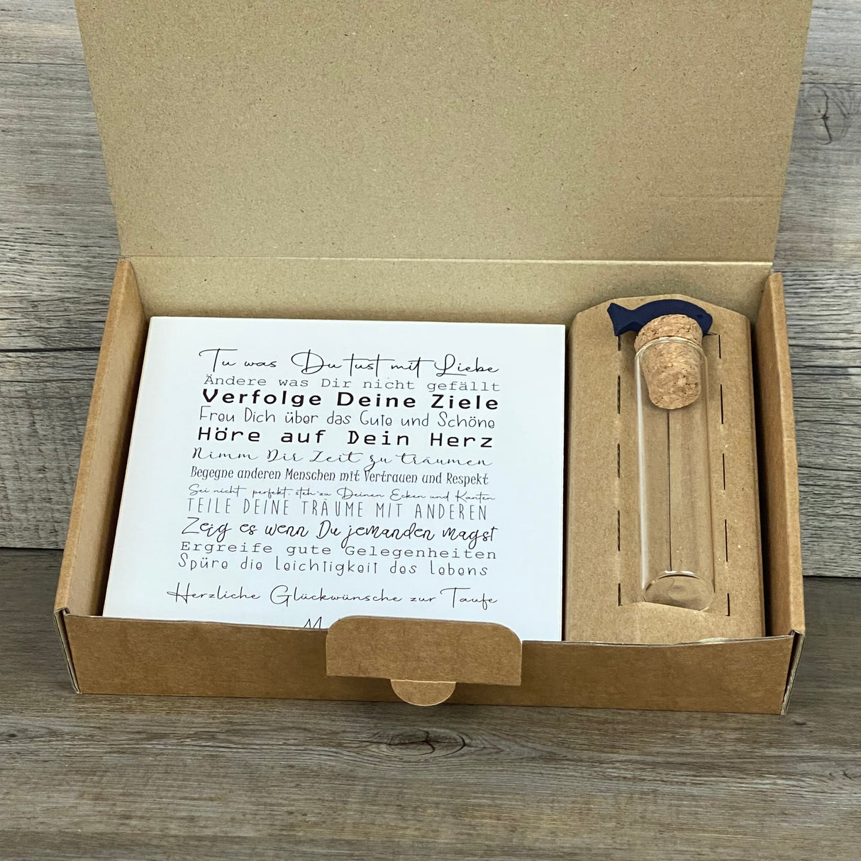 Verschenke bleibende Erinnerungen zur Taufe mit diesem besonderen Set. Enthalten ist ein Wooden Block Art „Taufe“ (15 x 15 x 2,2 cm) mit lebensbejahenden Botschaften, personalisierbar mit dem Namen des Kindes. Dazu ein dekoratives Reagenzglas mit Korken & Deko-Fisch (Maße 13 x 2,5 cm) für Geldgeschenke oder Gutscheine. Alles verpackt in einer stilvollen Geschenkbox mit Auswahl zwischen Fisch- oder Kreuzmotiv. Handgefertigt, nachhaltig und einzigartig.