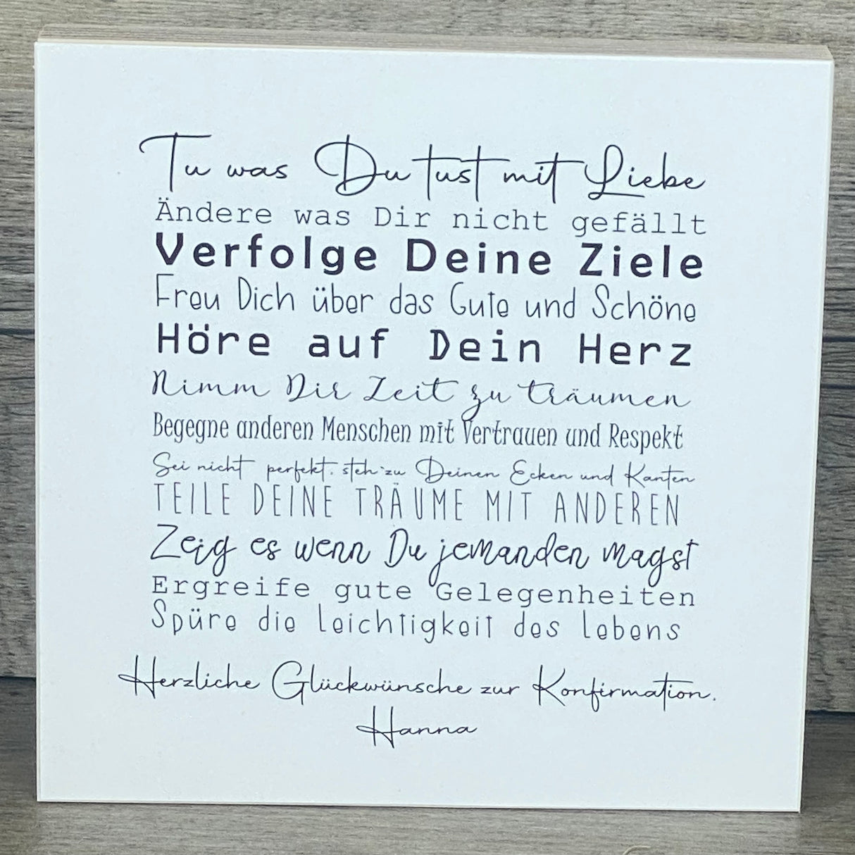 Dieses liebevoll gestaltete Geschenkset zur Konfirmation enthält einen dekorativen Wooden Block Art mit inspirierenden Lebensweisheiten. Auf Wunsch personalisierbar mit Namen, begleitet der Holzblock (15 x 15 x 2,2 cm) den Konfirmanden täglich mit motivierenden Botschaften. Ergänzt wird das Set durch ein Reagenzglas mit Korken und Fisch-Deko, ideal für Geldgeschenke oder Gutscheine. Verpackt in einer hochwertigen Geschenkbox mit christlichen Motiven, entsteht ein individuelles, nachhaltiges und unvergesslic