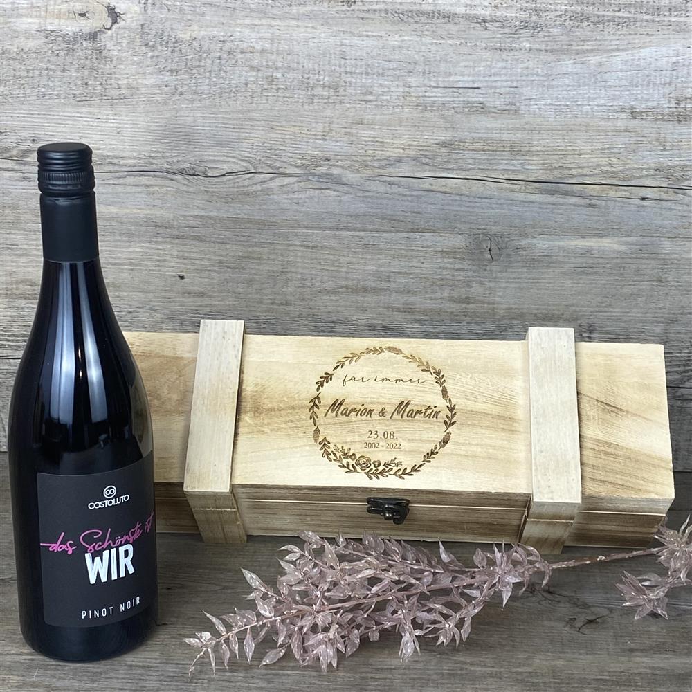 Diese elegante Weinkiste „für immer“ ist ein liebevolles Präsent für Brautpaare, Partner oder Freunde. Mit personalisierbarer Gravur, rustikalem Holz und filigranem Metallverschluss wird sie zu einem Unikat. Ideal für Weinliebhaber, romantische Anlässe oder als Erinnerung an unvergessliche Momente. Maße: 36 x 12 x 11 cm.