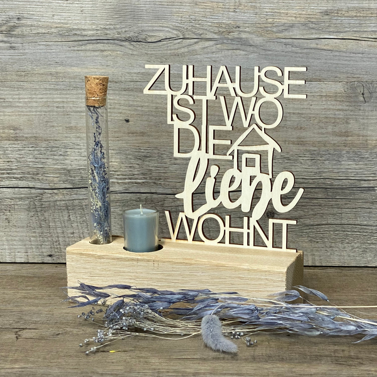 Variante 1 – Geschenk & Emotion
Romantischer Deko-Aufsteller Deluxe aus Eichenholz mit Pappelholz-Schriftzug „Zuhause, ist wo die Liebe wohnt“.
Ein liebevolles Geschenk für Einzug, Umzug, Hochzeit oder besondere Anlässe.
Personalisierbar mit Namen, Daten oder Koordinaten für ein einzigartiges Unikat.
Inklusive Reagenzglas mit Trockenblumen (blau oder rot) und Kerze – Maße ca. 20 x 6 x 5 cm.
Ein dekorativer Blickfang für Wohnzimmer, Flur oder als stilvolles Geschenk für Familie und Freunde.