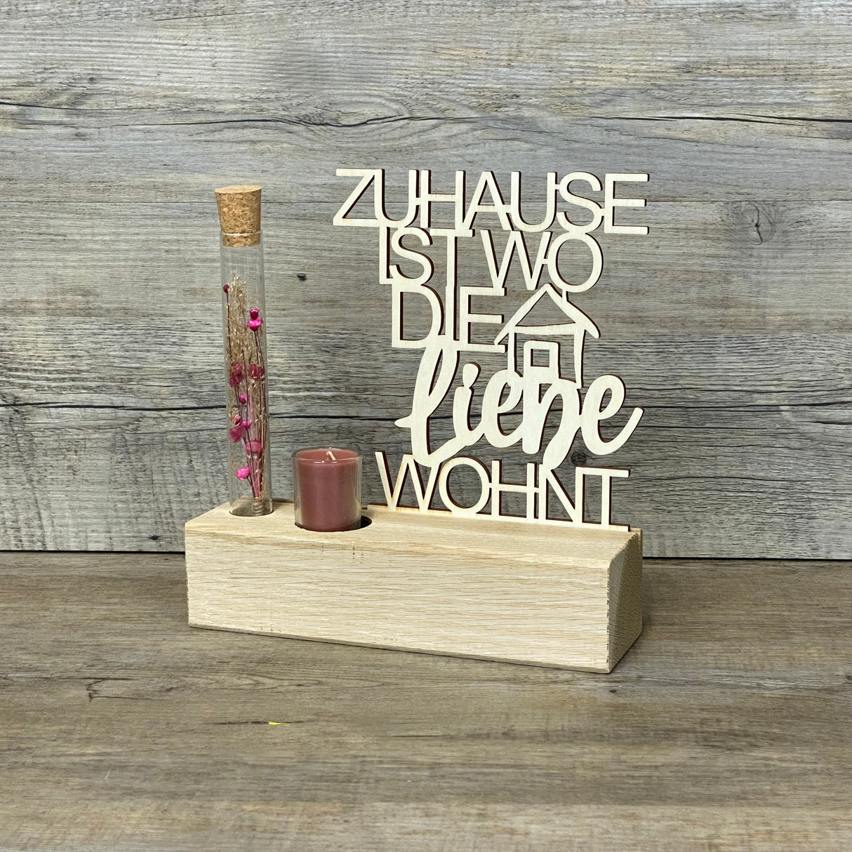 Variante 1 – Geschenk & Emotion
Romantischer Deko-Aufsteller Deluxe aus Eichenholz mit Pappelholz-Schriftzug „Zuhause, ist wo die Liebe wohnt“.
Ein liebevolles Geschenk für Einzug, Umzug, Hochzeit oder besondere Anlässe.
Personalisierbar mit Namen, Daten oder Koordinaten für ein einzigartiges Unikat.
Inklusive Reagenzglas mit Trockenblumen (blau oder rot) und Kerze – Maße ca. 20 x 6 x 5 cm.
Ein dekorativer Blickfang für Wohnzimmer, Flur oder als stilvolles Geschenk für Familie und Freunde.