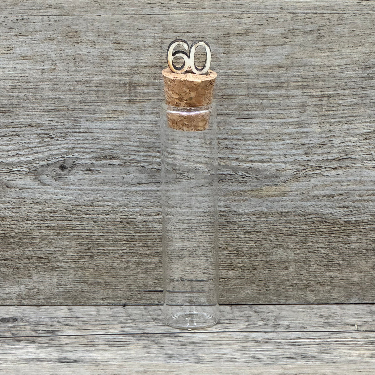 Feiere die Diamantene Hochzeit mit diesem stilvollen Geschenkset. Ein personalisierbarer Holzblock mit Aufschrift wie Lieben, Hoffen, Wachsen erinnert an 60 gemeinsame Jahre. Ein dekoratives Reagenzglas mit Holz-Zahl '60' eignet sich ideal für Gutscheine oder Geldgeschenke. Das Set wird in einer hochwertigen Geschenkbox mit dem Spruch „Der schönste Weg ist der Gemeinsame“ geliefert und ist ein einzigartiges Präsent für das Jubelpaar.
