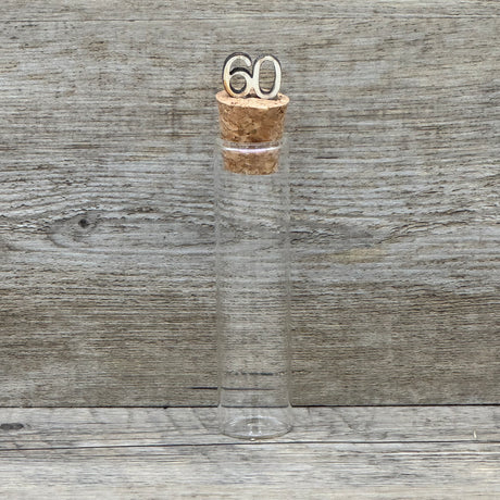 Feiere die Diamantene Hochzeit mit diesem stilvollen Geschenkset. Ein personalisierbarer Holzblock mit Aufschrift wie Lieben, Hoffen, Wachsen erinnert an 60 gemeinsame Jahre. Ein dekoratives Reagenzglas mit Holz-Zahl '60' eignet sich ideal für Gutscheine oder Geldgeschenke. Das Set wird in einer hochwertigen Geschenkbox mit dem Spruch „Der schönste Weg ist der Gemeinsame“ geliefert und ist ein einzigartiges Präsent für das Jubelpaar.
