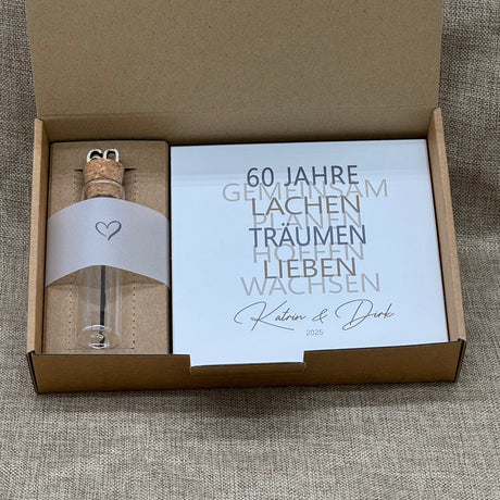 Zum 60. Hochzeitstag ist dieses Geschenkset eine wundervolle Erinnerung an gemeinsame Jahre. Es enthält einen handgefertigten Holzblock mit den Worten 60 Jahre, Lachen, Träumen, Lieben und Wachsen, personalisierbar mit Namen und Datum. Dazu ein Reagenzglas mit Holz-Zahl '60' für Geldgeschenke. Verpackt in einer liebevollen Geschenkbox mit dem Spruch „Der schönste Weg ist der Gemeinsame“ – perfekt für das Jubelpaar.
