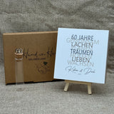 Zum 60. Hochzeitstag ist dieses Geschenkset eine wundervolle Erinnerung an gemeinsame Jahre. Es enthält einen handgefertigten Holzblock mit den Worten 60 Jahre, Lachen, Träumen, Lieben und Wachsen, personalisierbar mit Namen und Datum. Dazu ein Reagenzglas mit Holz-Zahl '60' für Geldgeschenke. Verpackt in einer liebevollen Geschenkbox mit dem Spruch „Der schönste Weg ist der Gemeinsame“ – perfekt für das Jubelpaar.
