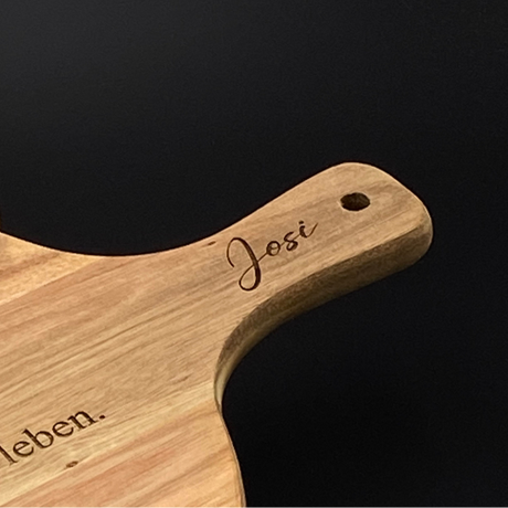 Ein liebevolles Geschenk für Freunde oder Paare: das runde Akazienholz-Pizzabrett mit personalisierter Lasergravur. Mit Namen oder witzigem Spruch wird es zu einem persönlichen Unikat. Optimal für Pizza, Flammkuchen oder Tapas, dekorativ und funktional zugleich. Die natürliche Maserung macht jedes Brett einzigartig. Perfekt für Geburtstage, Einzugspartys, Grillabende oder als originelle Aufmerksamkeit. Ein stilvolles und praktisches Küchenaccessoire.
