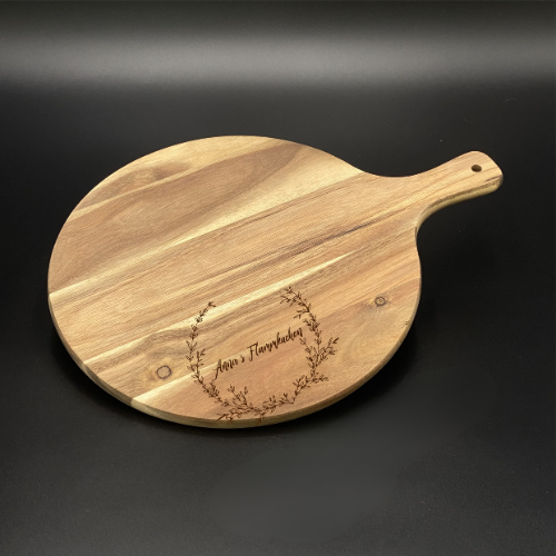 Ein liebevolles Geschenk für Freunde oder Paare: das runde Akazienholz-Pizzabrett mit personalisierter Lasergravur. Mit Namen oder witzigem Spruch wird es zu einem persönlichen Unikat. Optimal für Pizza, Flammkuchen oder Tapas, dekorativ und funktional zugleich. Die natürliche Maserung macht jedes Brett einzigartig. Perfekt für Geburtstage, Einzugspartys, Grillabende oder als originelle Aufmerksamkeit. Ein stilvolles und praktisches Küchenaccessoire.
