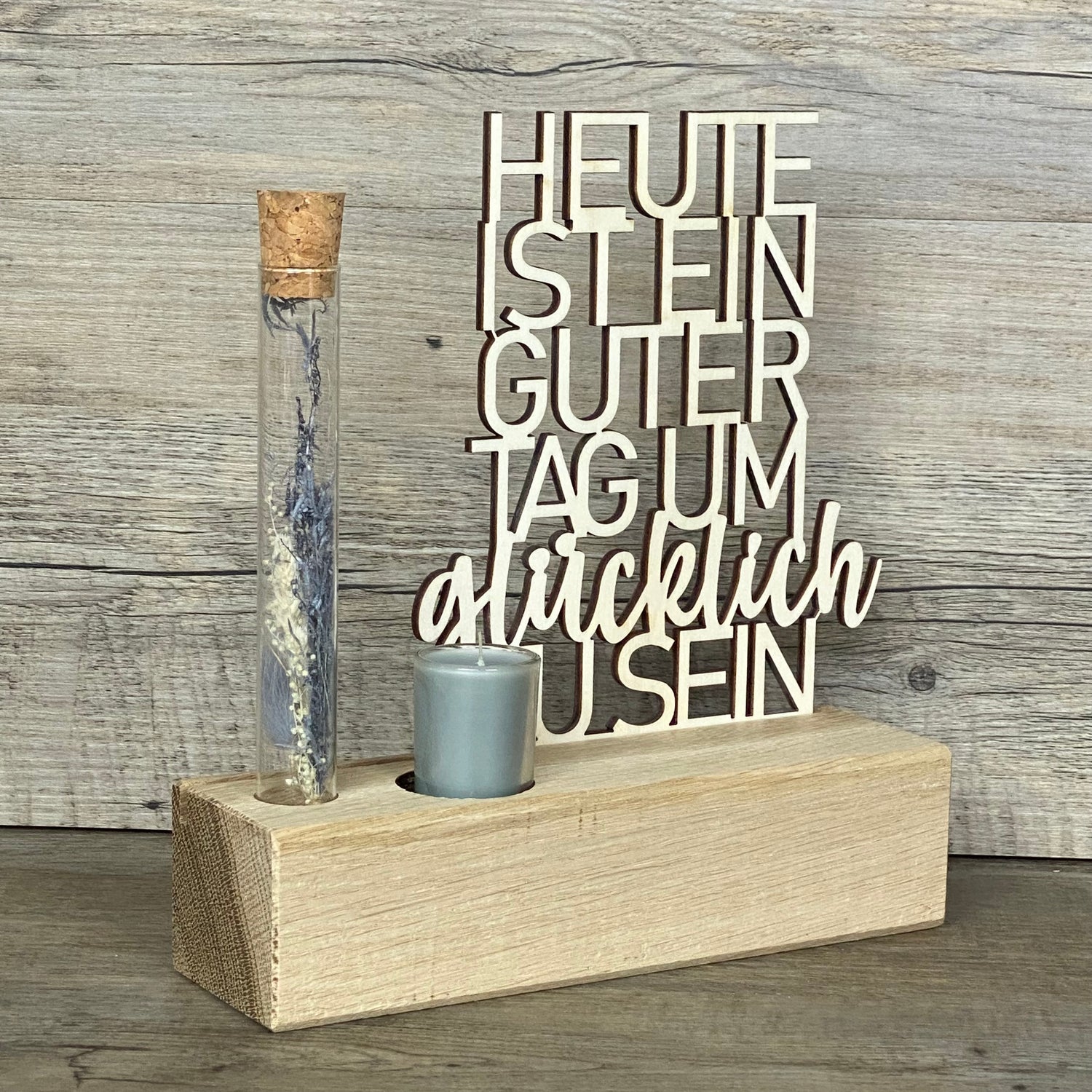 Deko Aufsteller Deluxe „Heute ist ein guter Tag um glücklich zu sein“ – das perfekte Geschenk für deine Lieblingsmenschen.  
Hochwertiger Aufsteller aus Eichenholz mit Schriftzug aus 3 mm Pappelholz.  
Inklusive Reagenzglas mit Trockenblumen und Kerze – wählbar in Blau oder Rot.  
Maße: Aufsteller ca. 20 x 6 x 5 cm, Geschenkverpackung ca. 25 x 20 x 7 cm.  
Personalisierbar mit Namen, Daten oder Koordinaten für ein einzigartiges Unikat.
