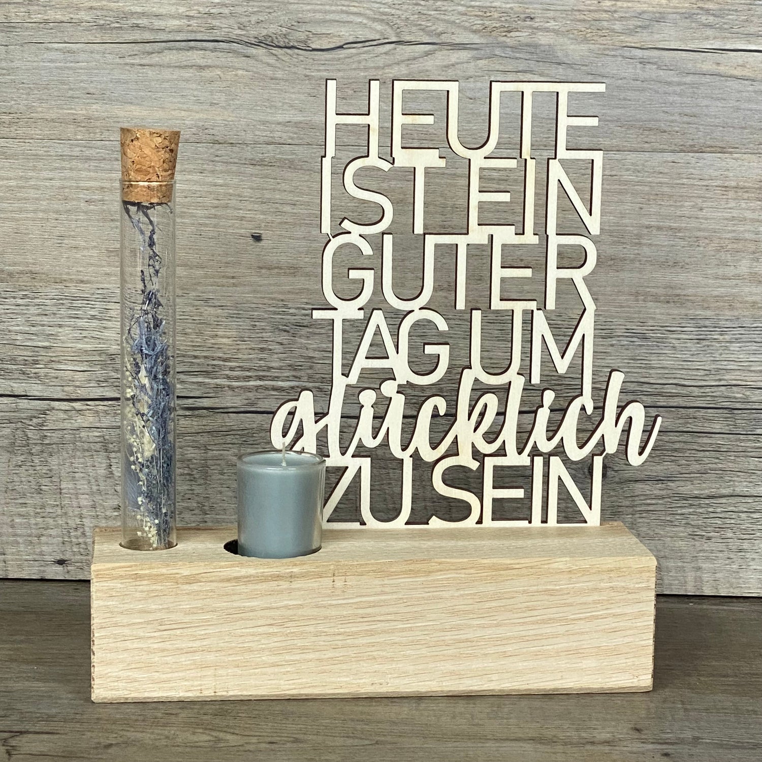 Verschenke Freude mit dem Deko Aufsteller Deluxe „Heute ist ein guter Tag um glücklich zu sein“.  
Gefertigt aus hochwertigem Eichenholz, Schriftzug aus Pappelholz, inklusive Reagenzglas mit Trockenblumen und Kerze.  
Größe Aufsteller: ca. 20 x 6 x 5 cm, Schriftzug ca. 15 x 18 cm, Geschenkverpackung ca. 25 x 20 x 7 cm.  
Trockenblumen und Kerze in Blau oder Rot erhältlich – Naturprodukt, Abweichungen möglich.  
Personalisierbar mit Namen, Datum oder Koordinaten – ein individuelles Geschenk für jeden Anlass.
