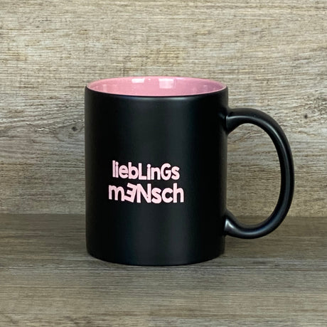 Diese personalisierte Keramik-Tasse „Lieblingsmensch“ ist ein liebevolles Geschenk für besondere Menschen. Schwarze Außenseite, farbige Innenseite (weiß, rot, orange, pink, grün oder gelb), 350 ml Fassungsvermögen, Maße ca. Ø 8,2 × 9,6 cm. Vorderseite mit Lasergravur „Lieblingsmensch“, optional mit Wunschnamen auf der Rückseite. Ideal für Geburtstage, Jubiläen, Valentinstag oder als kleine Aufmerksamkeit.
